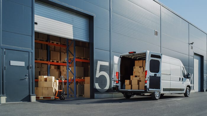 Delivery van parked outside a warehouse