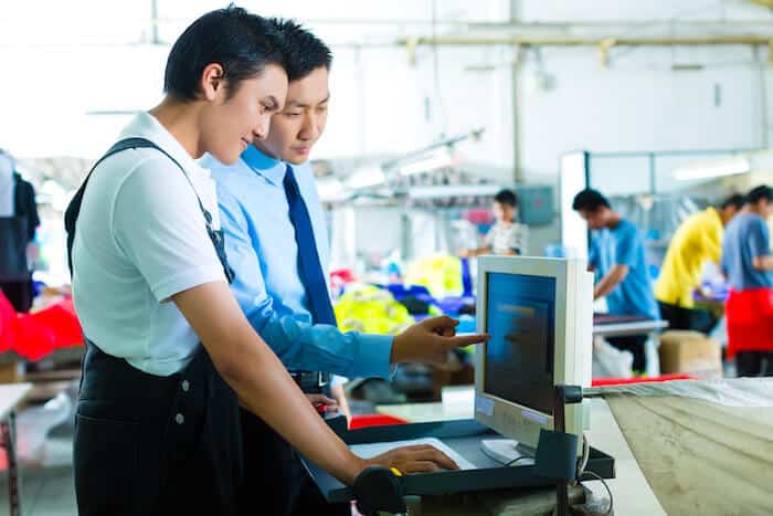 Manager teaching an employee how to use a computer